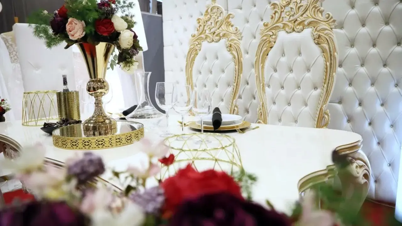 Elegancki stół z kwiatami i złotymi zdobieniami. Czy za ślub cywilny się płaci? Tutaj wszystko wygląda na luksusowe.