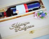 Elegancka skrzynka na wino dla chrzestnych z napisem "Kochanym Rodzicom" i ozdobną kokardką z kwiatami.