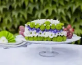 Inspiracja na bukiety na stół weselny: kwiatowy tort z chryzantem, chabrów i winogron na paterze.