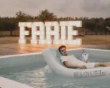 Relaks przy basenie z drinkiem, wielkie litery "FARTE" w tle. Idealny pomysł, jak zorganizować wieczór kawalerski.