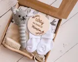 Zestaw na baby shower: szydełkowy kotek, skarpetki, szczotka i tabliczka "Witaj na świecie Maleństwo". Idealny pomysł, ile dać na baby shower.