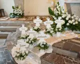 Urocze pomysły na dekoracje komunijne w kościele: aniołki z imionami dzieci i białe kwiaty tworzą niebiańską atmosferę.