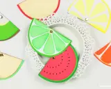 Kolorowe, owocowe zaproszenia na roczek diy: plasterki limonki, arbuza, cytryny, pomarańczy i jabłka.
