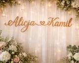 Drewniane imiona na ściankę weselną: Alicja i Kamil, ozdobione kwiatami i światełkami.