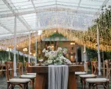 Eleganckie dekoracje stołów weselnych nowości: drewniane stoły, bukiety kwiatów i mnóstwo światełek tworzą magiczną atmosferę.