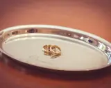 Złote obrączki na srebrnej tacce z grawerem "mężu przyjmij tę obrączkę".