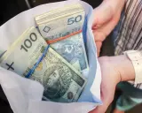 Koperta z plikiem banknotów 100 i 50 zł. Ile dać na 50 urodziny? Tyle pieniędzy to dobry prezent!