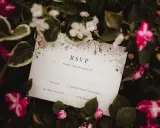 Karta RSVP z kwiatowym wzorem wśród zieleni i różowych kwiatów.