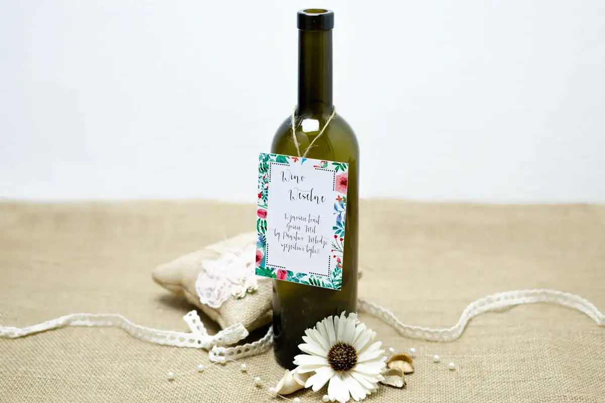 Eleganckie napisy na zawieszki na alkohol, ozdobione kwiatowym wzorem, dodają uroku butelce wina.