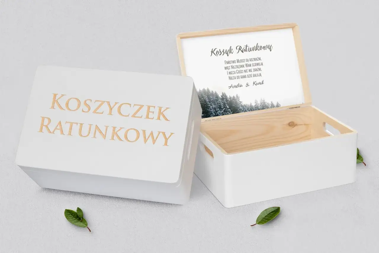 Biały koszyczek ratunkowy z wygrawerowanym napisem. W środku otwarta skrzynka z życzeniami dla Młodej Pary i zimowym krajobrazem.