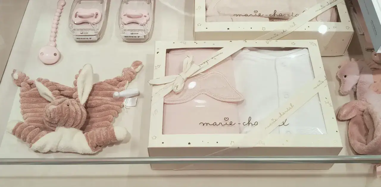 Różowe akcesoria dla niemowląt: przytulanka, smoczki i zestaw ubranek. Idealne na baby shower, zastanawiasz się, ile dać na baby shower?