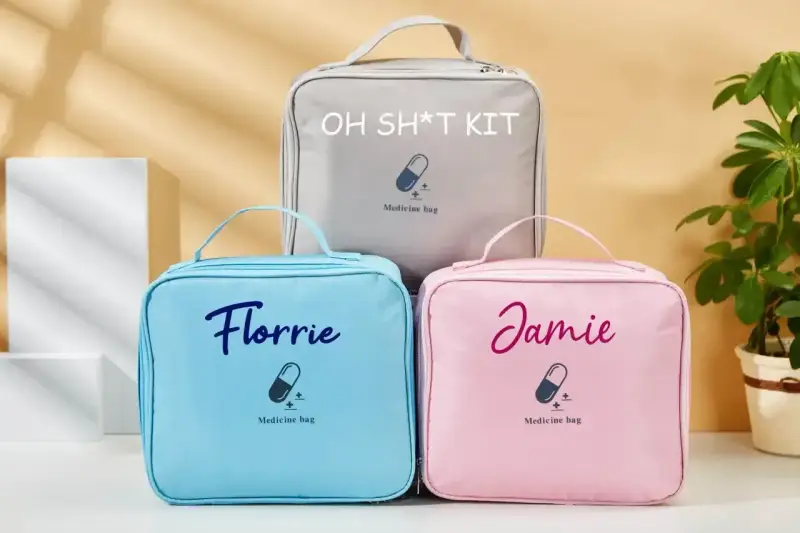 Trzy kosmetyczki: szara z napisem "OH SH*T KIT", niebieska "Florrie" i różowa "Jamie". Idealne, by wiedzieć, co zabrać na wesele, gdyby coś poszło nie tak.